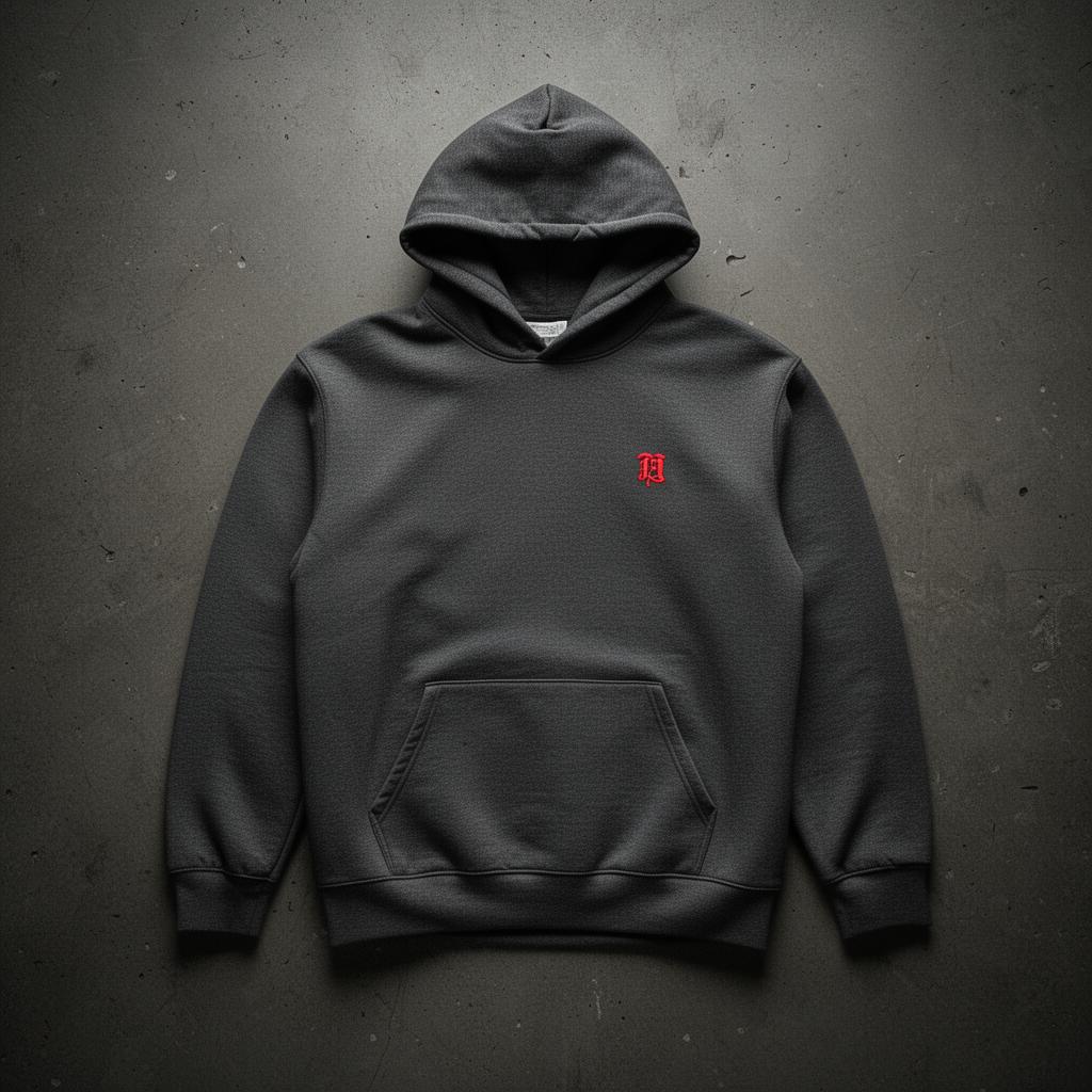 Charcoal-gray midweight hoodie with a small embroidered red ledger mark on the chest.